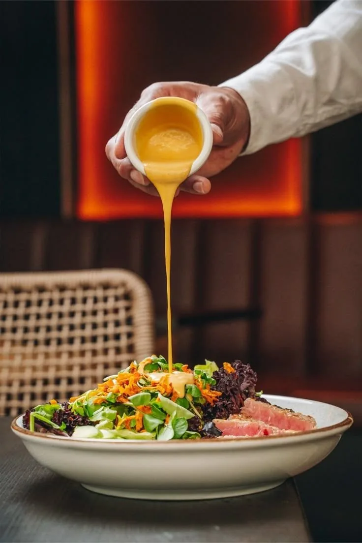 L'inspiration choisie : une salle de restaurant sombre, un néon rouge, un chef qui verse la sauce