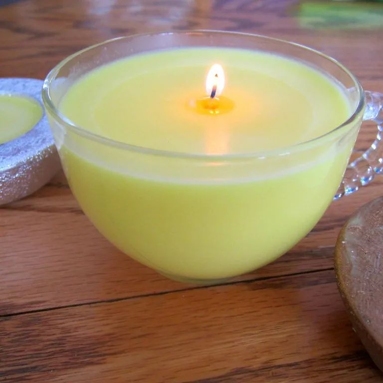 La photo de départ : une bougie jaune dans une tasse en verre, posée sur une table en bois