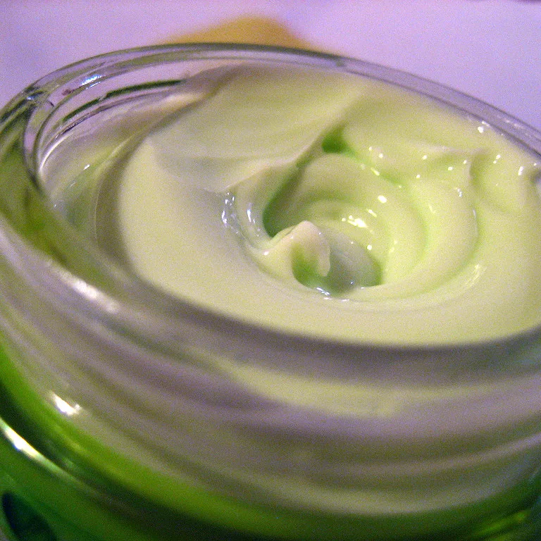 La photo de départ : un pot de crème verte en gros plan, sur un fond violet