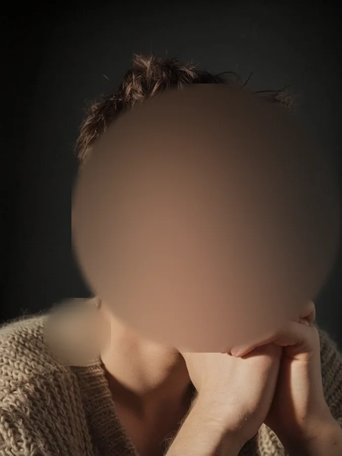 La scène&nbsp;: un portrait sur fond sombre, mains sous le menton, visage flouté