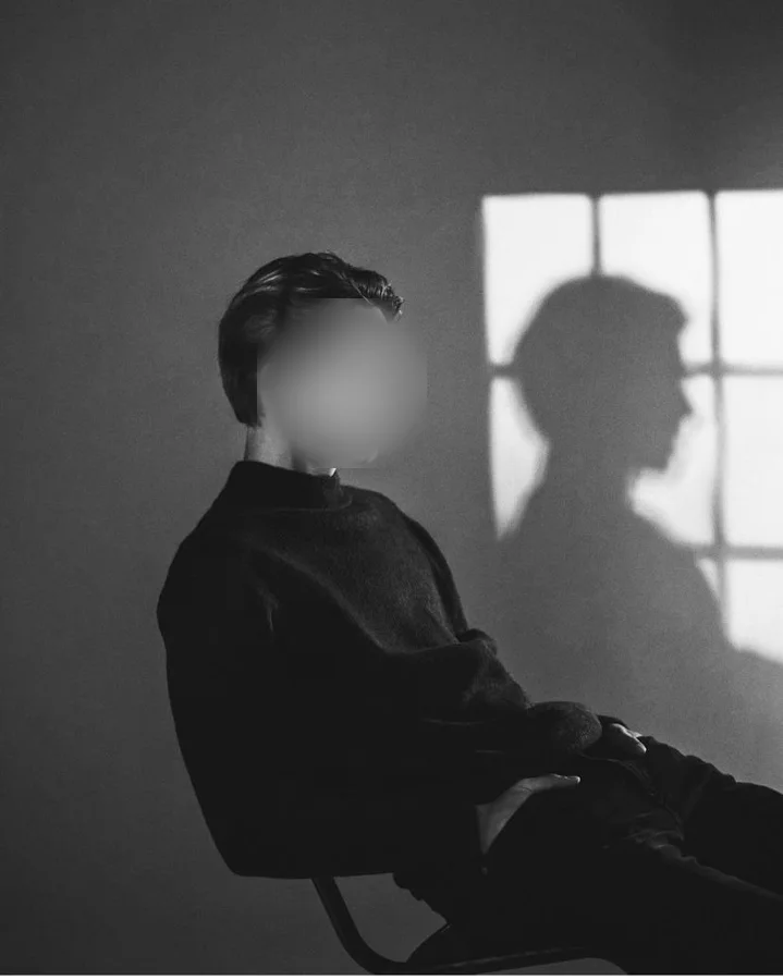 La scène&nbsp;: un homme assis de profil en noir et blanc, l'ombre d'une fenêtre, visage flouté