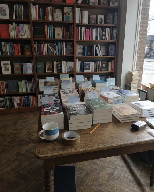 Photo de départ : libraire, avancée lente vers la table des nouveautés, avec ses cartes « coup de cœur » écrites à la main