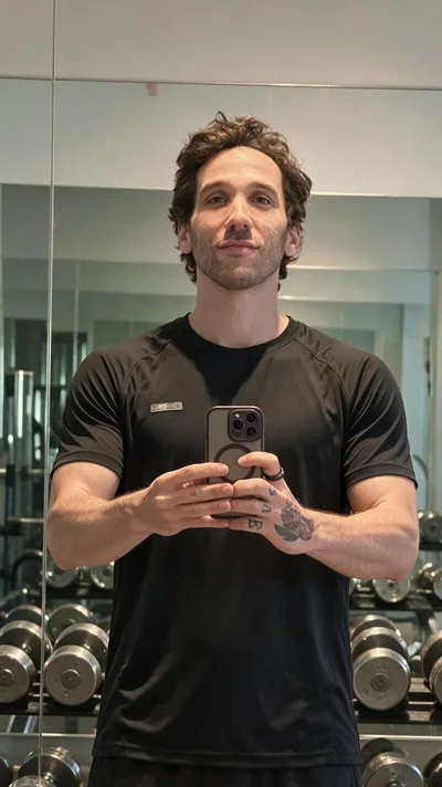La retouche : le même selfie au miroir d'une salle de sport, t-shirt technique noir, haltères derrière