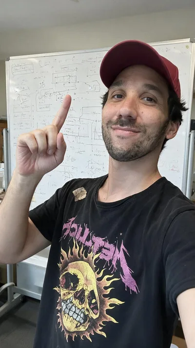 La retouche&nbsp;: le même selfie dans une salle de formation, tableau blanc couvert de schémas, t-shirt imprimé