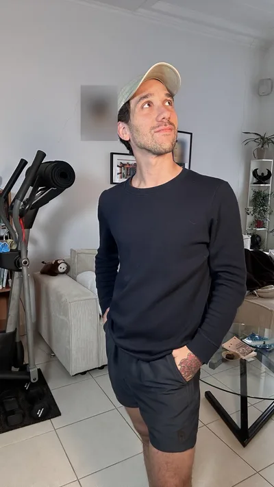 Ma photo de départ : debout chez moi, pull marine, short, mains dans les poches
