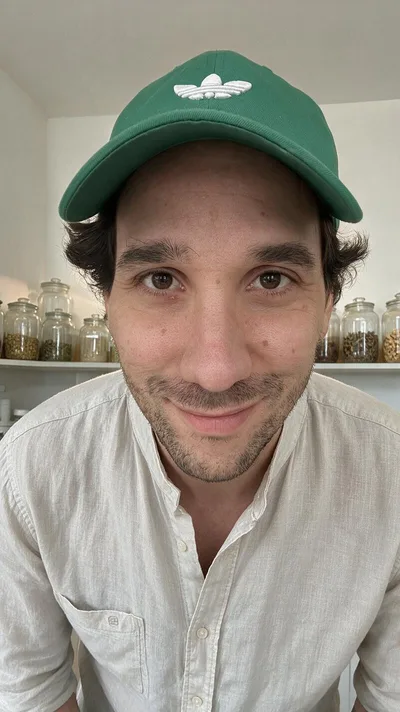 La retouche : le même gros plan dans un cabinet de naturopathe, chemise de lin, bocaux de plantes