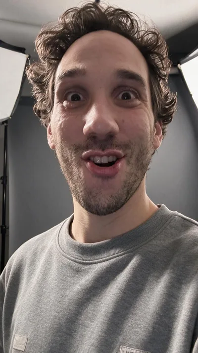 La retouche : la même expression dans un studio photo, sweat gris, boîte à lumière derrière
